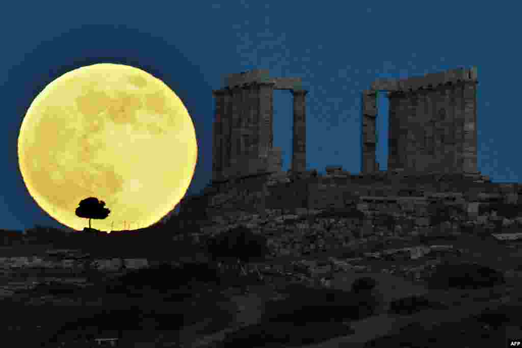 Bulan purnama &quot;super&quot; tampak di belakang kuil Yunani kuno Poseidon di Cape Sounion, sekitar 65 kilometer sebelah selatan Athena, Yunani.