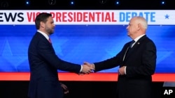 Republican vice presidential nominee Senator JD Vance, left, and Democratic vice presidential nominee Minnesota Governor Tim Walz shake hands as they arrive for a CBS News vice presidential debate in New York, Oct. 1, 2024.