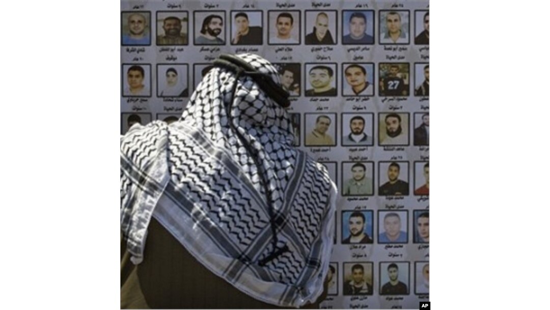 A Palestinian man looks at pictures of Palestinians imprisoned in Israeli jails, Thursday, April 15, 2010. Palestinians marked the annual prisoner's day by calling for the release of over 11,000 Palestinian prisoners, including women and children, curre