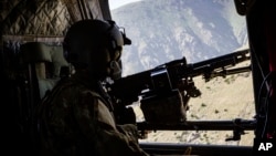 A photo released by Operation Resolite Support shows a US Army CH-47 Chinook helicopter crew scanning below near Mazar-e-Sharif, Afghanistan, June 9, 2017. 