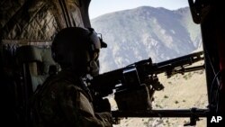 FILE - A US Army CH-47 Chinook helicopter crew scanning below near Mazar-e-Sharif, Afghanistan, June 9, 2017. 