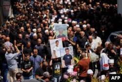 Para pelayat mengusung peti jenazah Guevara Ibrahim, seorang anak berusia 11 tahun yang tewas dalam serangan yang diduga berasal dari Lebanon dua hari sebelumnya, saat pemakaman di kota Druze, Majdal Shams, di Golan yang dianeksasi Israel, 29 Juli 2024. (Foto: AFP)