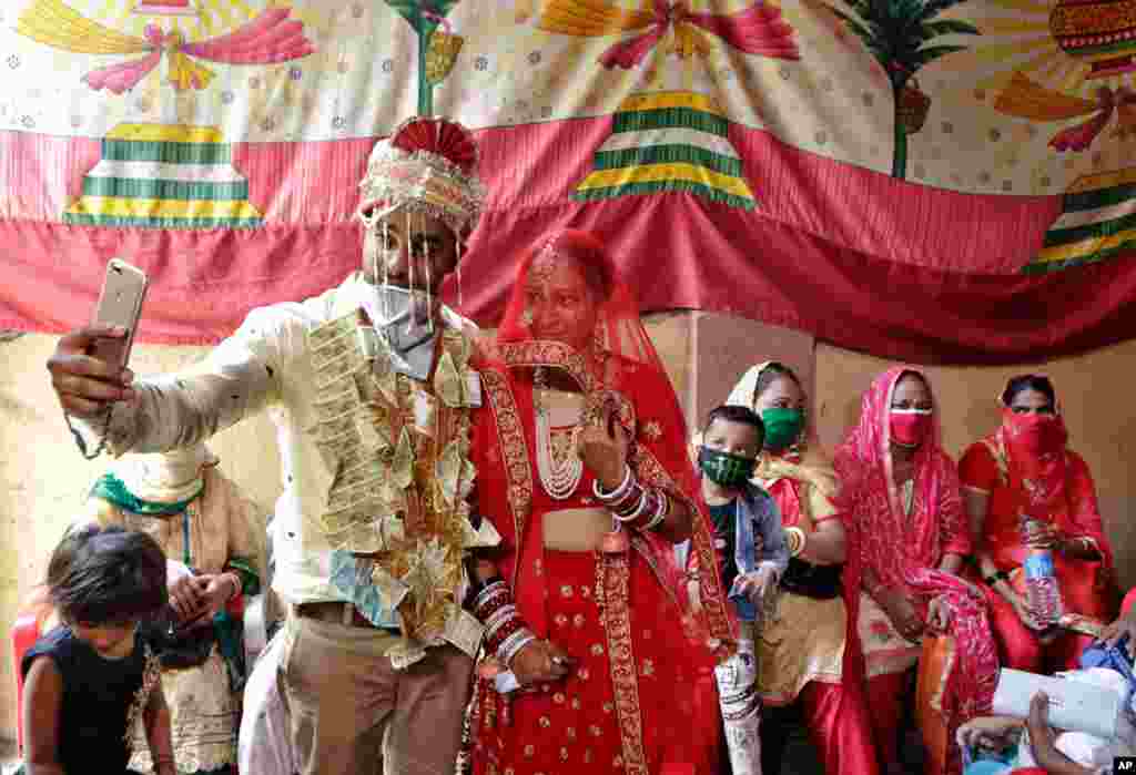 یک زوج هندی در حاشیه مراسم ازدواج‌شان از خود سلفی می‌گیرند. محدودیت‌های بعد از کرونا در این کشور افزایش یافته است. در هند ۳۳۳ هزار نفر به کرونا مبتلا شده‌اند و ۹.۵ هزار نفر جان باخته‌اند. 