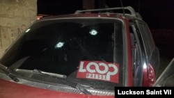 Luckson Saint Vil's car is seen with bullet holes piercing the windshield and hood.