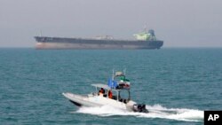 Perahu motor garda revolusi Iran melakukan patroli di Teluk Persia, sementara sebuah kapal tanker tampak di belakang (foto: ilustrasi). 