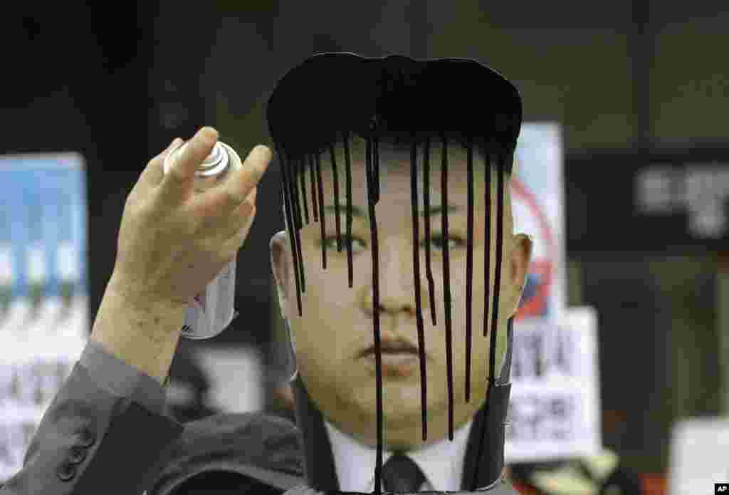A picture of North Korean leader Kim Jong Un is sprayed by an anti-North Korean protester during an anti-North Korea rally against recent missile launches and provocative acts, on the birthday of its founder, Kim Il Sung, in Seoul, South Korea.