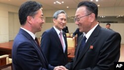 FILE - North Korea's Kim Yang Gon, right, speaks with South Korean Unification Minister Hong Yong-pyo, left, after their meeting at the border village of Panmunjom in Paju, South Korea, Aug. 25, 2015. 