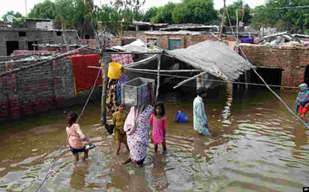 People move their belongings after their houses become flooded, September 16, 2011, in Hyderabad, Pakistan. (AP)
