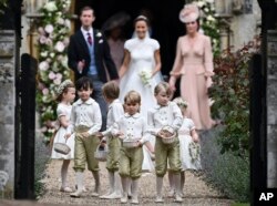 FILE - Britain's Prince George, foreground center, reacts after the wedding of his aunt, Pippa Middleton to James Matthews, at St Mark's Church in Englefield, England on May 20, 2017.