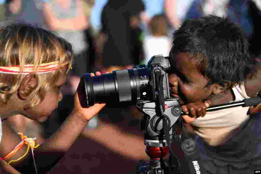 Indigenous Anangu children play with a camera during a ceremony marking the permanent ban on climbing Uluru, also known as Ayers Rock, at Uluru-Kata Tjuta National Park in Australia&#39;s Northern Territory.