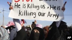 Syrian protester holds up a sign as she takes part in a protest calling for Syria's President Bashar al-Assad to step down, in front of the Syrian embassy in Amman, May 1, 2011