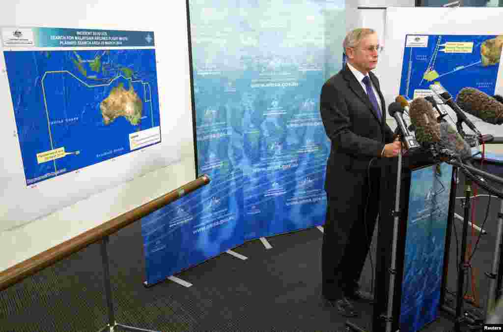 John Young, general manager of the emergency response division of the Australian Maritime Safety Authority, answers a question as he stands in front of a diagram showing the search area for flight MH370 during a briefing in Canberra, March 20, 2014. 