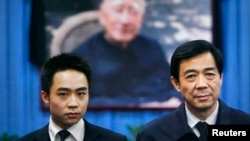 China's former Chongqing Municipality Communist Party Secretary Bo Xilai (R) and his son Bo Guagua stand in front of a picture of his father Bo Yibo, former vice-chairman of the Central Advisory Commission of the Communist Party of China. (File photo)