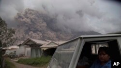 Warga mengungsi dengan truk saat Gunung Sinabung melepaskan awan panas dalam letusannya hari Rabu, 2 Agustus 2017 di Karo, Sumatra Utara, Indonesia (foto: AP Photo/Endro Rusharyanto)