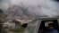 Residents ride in a truck as Mount Sinabung releases pyroclastic flows during its eruption in Karo, North Sumatra, Indonesia, Aug. 2, 2017.