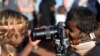 Indigenous Anangu children play with a camera during a ceremony marking the permanent ban on climbing Uluru, also known as Ayers Rock, at Uluru-Kata Tjuta National Park in Australia&#39;s Northern Territory.