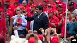 FILE - Venezuela's President Nicolas Maduro speaks to workers of the state-run oil company during a demonstration outside Miraflores Presidential Palace in Caracas, Venezuela, June 22, 2016.