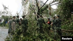 Cảnh sát bán quân sự dọn dẹp cây cối bị đổ sau khi bão Meranti quét qua Hạ Môn, tỉnh Phúc Kiến, Trung Quốc, ngày 15/9/2016.