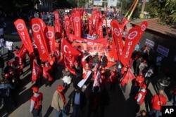 Protesters wave banners at a peace rally organised by the country's public sector workers' trade union, prior to explosions, in Ankara, Oct. 10, 2015.