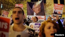 FILE - People shout slogans as in front of a placard depicting former U.S Secretary of State Henry Kissinger (C), during a protest calling for the release of Jonathan Pollard from a U.S. prison, outside U.S. Secretary of State John Kerry's hotel in Jerusalem, January 2, 2014.