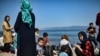 Des migrants afghans arrivent après avoir traversé la mer Égée depuis la Turquie avec un canot pneumatique sur l'île grecque de Lesbos, le 6 août 2018.