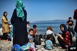 FILE - Migrants from Afghanistan arrive after crossing the Aegean Sea from Turkey with a dinghy on the Greek Mediterranean island of Lesbos on Aug. 6, 2018.