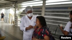 Una mujer recibe una dosis de la vacuna contra la enfermedad por coronavirus de Pfizer-BioNTech (COVID-19) en la estación de Bus Rapid Transit (BRT) en Río de Janeiro, Brasil, el 27 de octubre de 2021.