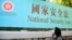 一名女性走過宣傳“港版國安法”的橫幅。（2020年6月30日）