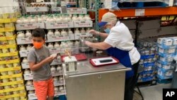 Seorang pekerja menawarkan sampel wafel yang dibumbui dengan sirup maple unggulan di Costco, Lone Tree, Colorado, Kamis, 17 Juni 2021. (AP Photo/David Zalubowski)
