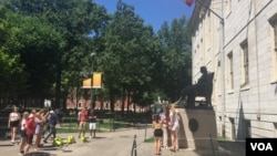 遊人與哈佛大學的約翰哈佛銅像合影。