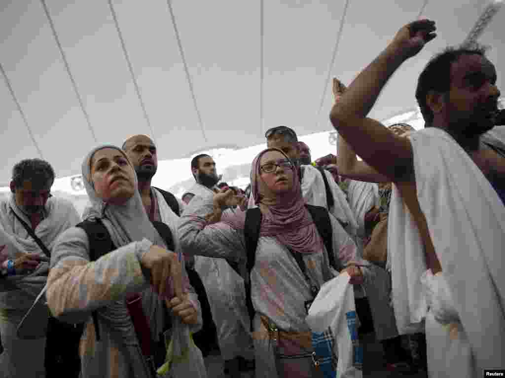 Jemaah haji melemparkan batu ke tiang-tiang yang melambangkan setan dalam ritual terakhir ibadah haji, yang disebut jumrah, sebelum awal hari raya Idul Adha (24/9). (Reuters/Ahmad Masood)