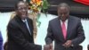 FILE - Zimbabwean President Robert Mugabe, left, shakes hands with Prime Minister Morgan Tsvangirai, May 22, 2013, after he signed the new constitution into law in Harare.