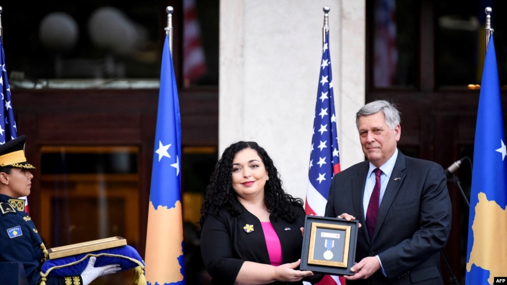 科索沃总统维约萨·奥斯马尼（中）在颁奖典礼上将勋章交给美国大使菲利普·克斯内特。(photo:VOA)