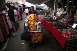 A street vender pushes a cart with piggy banks in a market in Bangkok, Sept. 4, 2019. World Bank records show the poverty in Thailand declined in last 30 years, but the pace of the decline has slowed recently.