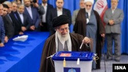 Pemimpin Tertinggi Iran Ayatollah Ali Khamenei memasukkan kartu suara dalam pemilu Iran hari Jumat (26/2).