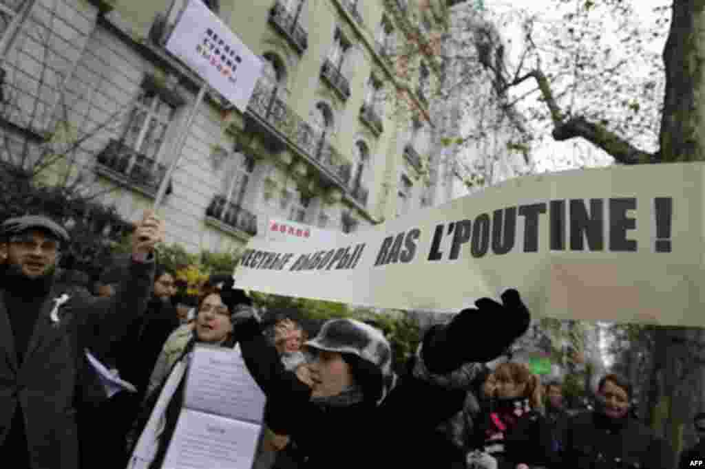 Demonstrators gather in front of the Russian embassy in Paris, Thursday, Dec. 8, 2011, to protest against Russian Prime Minister Vladimir Putin and his party, which won the largest share of a parliamentary election that observers said was rigged. Poster r