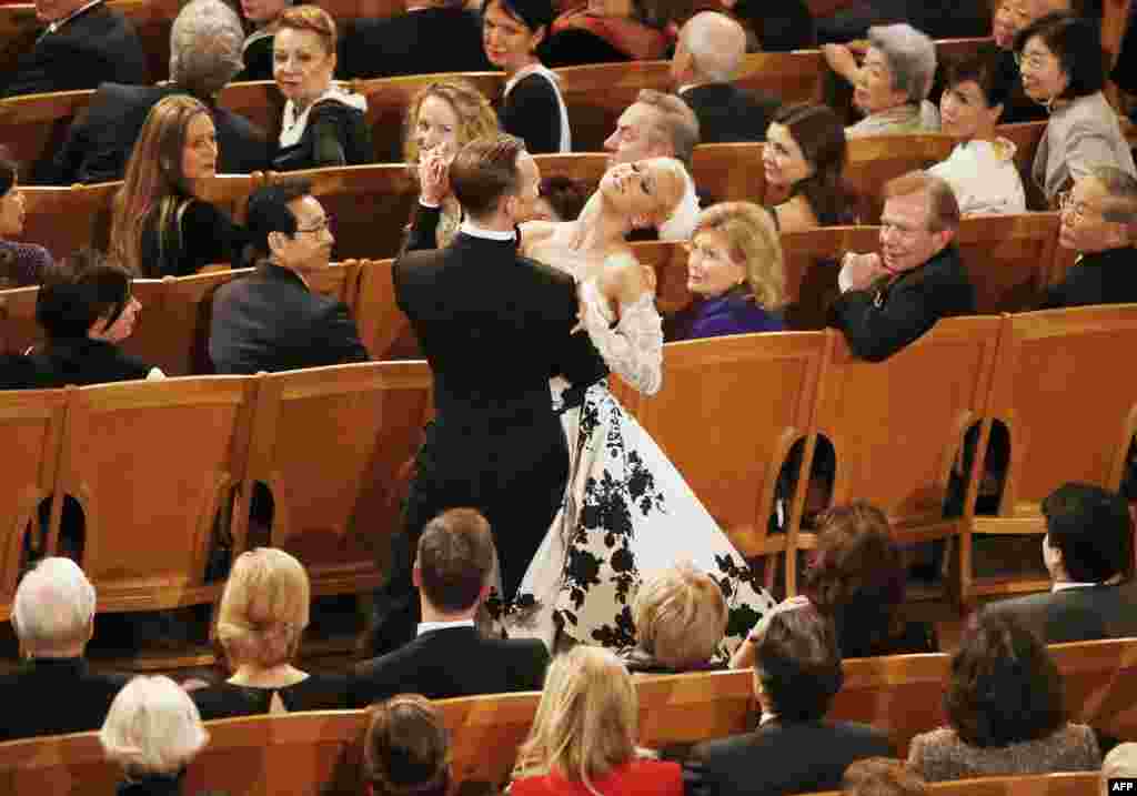 A couple dances in the &quot;Golden Hall&quot; as Israeli Argentine-born conductor Daniel Barenboim conducts the Vienna Philharmonic Orchestra during the New Year&#39;s Concert in Vienna. 