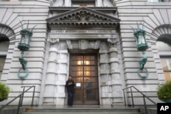 FILE - A man stands outside the main door of the 9th U.S. Circuit Court of Appeals building in San Francisco, Feb. 9, 2017.