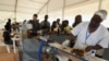 FILE - Visitors watch as employees of a Chocolatier in the Ivory Coast explain and show the different stages of processing cocoa into chocolate during the 5th edition of the ice cream and chocolate festival in Abidjan on May 19, 2018. 