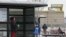 A woman and her grandson wait for a bus, near the fenced-in Century movie theater, the site of the deadly 2012 shootings, in Aurora, Colorado, January 15, 2013.