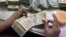 An employee counts Indian currency notes at a cash counter inside a bank in Kolkata, June 18, 2012. 
