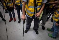 "Grandpa Wong," center, 85, leans on his walking stick with other "silver hair" volunteers after intervening in a confrontation between protesters and riot police in the Tung Chung district in Hong Kong, Sept. 7, 2019.