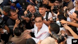 FILE- Thailand Prime Minister Prayuth Chan-ocha amid a crush of press photographers.