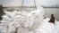 A migrant worker unloads sacks of rice from a barge to a cargo ship on The Chao Phraya River in Bangkok, Thailand, Aug. 27, 2014. 