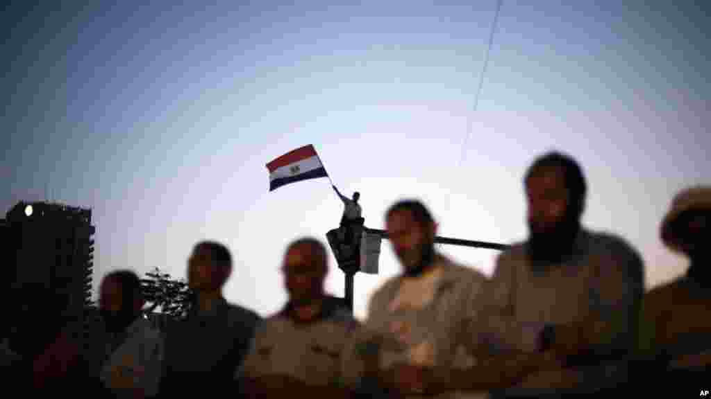  在解放广场上露营的埃及人作祷告。穆斯林兄弟会的高层领导人说，解放广场上的静坐示威要一直持续到当局收回解散议会的裁决。
