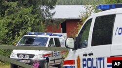 Norwegian police cars sit in front of the farm of Anders Behring Breivik, the suspect in the twin terror attacks that killed 76 people in Oslo and on Utoya island, in Asta, central Norway, July 28, 2011