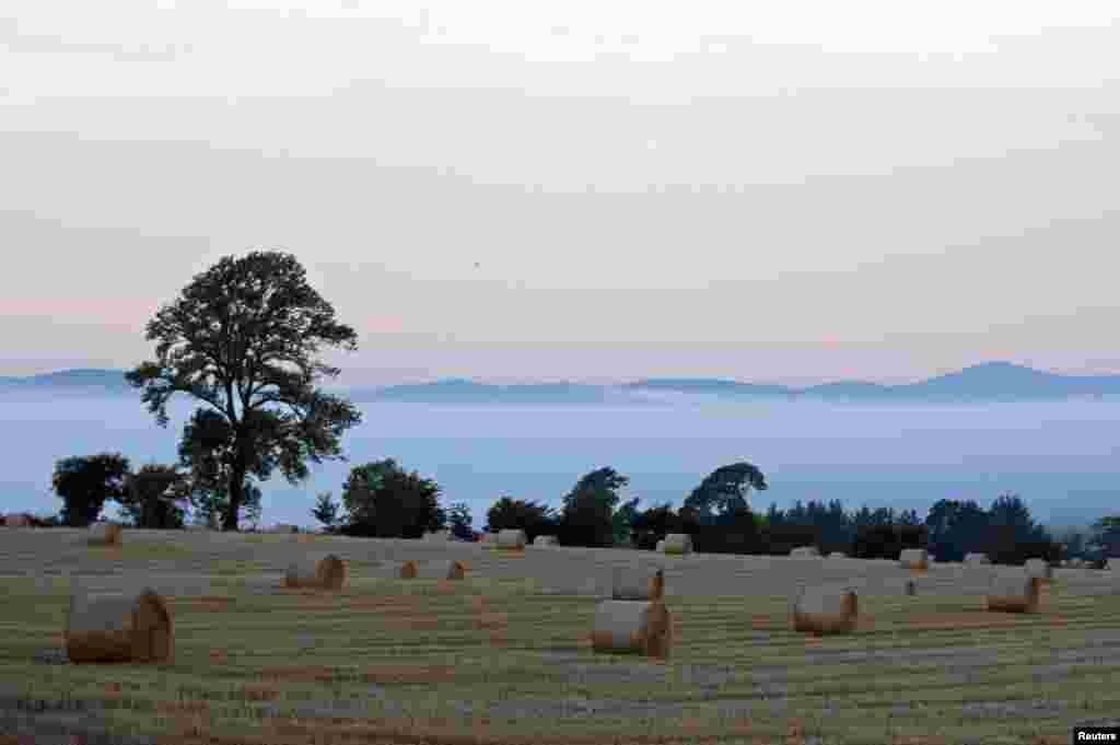 Straw bails are seen in a field on a misty autumn morning near Glamis in Angus, Scotland.