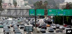 FILE - Vehicles are backed up while entering the US 101 Ventura Freeway as traffic from US 101 enters into downtown Los Angeles, Aug. 25, 2015.