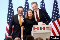 FILE - Mexican Economy Minister Ildefonso Guajardo, Canadian Foreign Minister Chrystia Freeland and U.S. Trade Representative Robert Lighthizer smile during a joint news conference on NAFTA talks in Mexico City, Mexico, March 5, 2018.