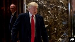 President-elect Donald Trump comes to the lobby to speak to members of the media at Trump Tower in New York, Tuesday, Dec. 6, 2016. (AP Photo/Andrew Harnik)